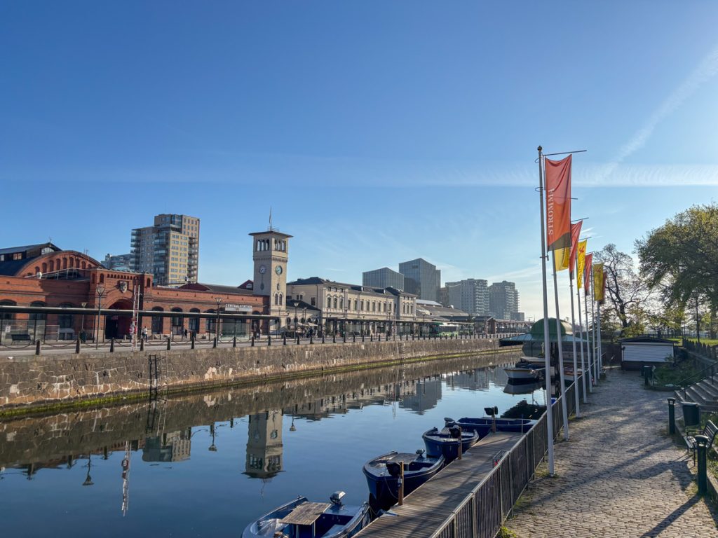 Malmö Central, sunshine, and a slice of canal under a nearly cloudless sky.